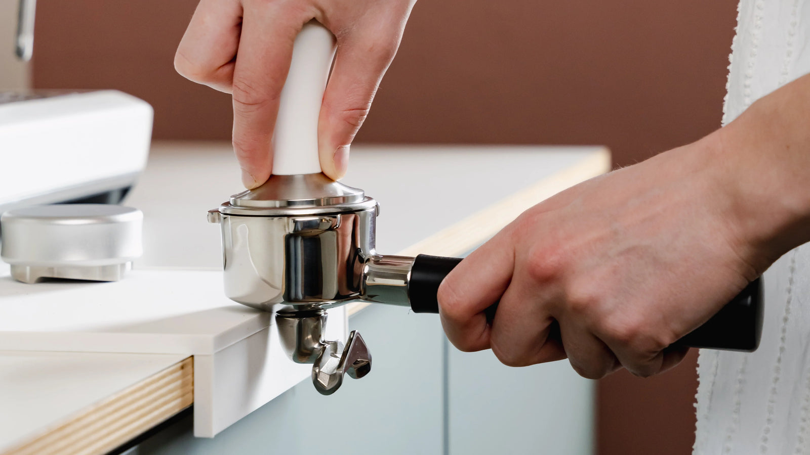 tamper 58,5mm hout volledig rvs met barista-essentials logo op aanrecht