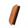 Wooden coffee brush with black bristles and “Barista Essentials” engraved on the handle.